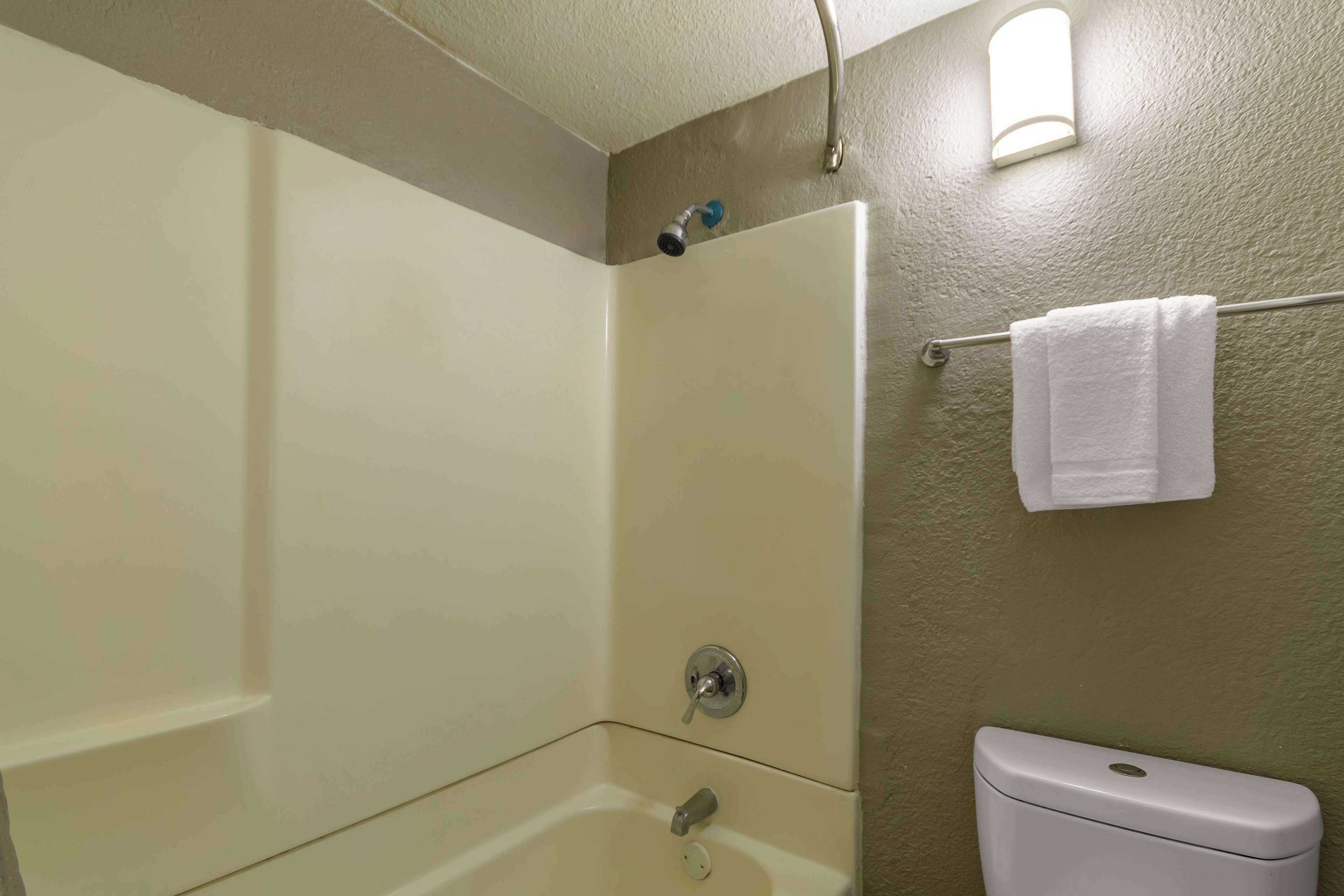 Ein Badezimmer mit Badewanne, Toilette und Handtuchhalter.