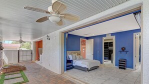 Une chambre à coucher avec un lit, une armoire et un ventilateur de plafond.