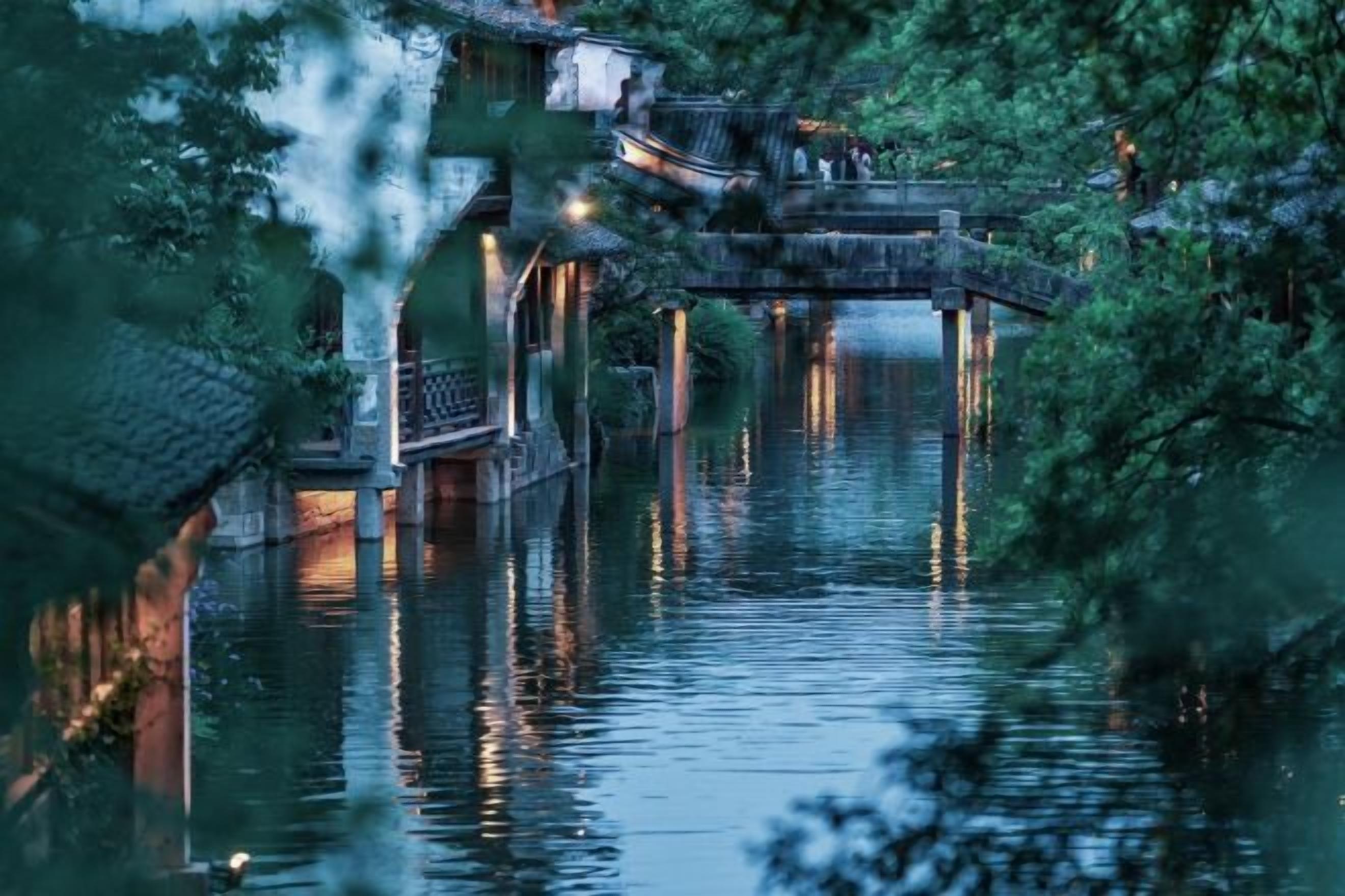 A traditional wooden structure over water, possibly a bridge or walkway, with a reflection in the water.