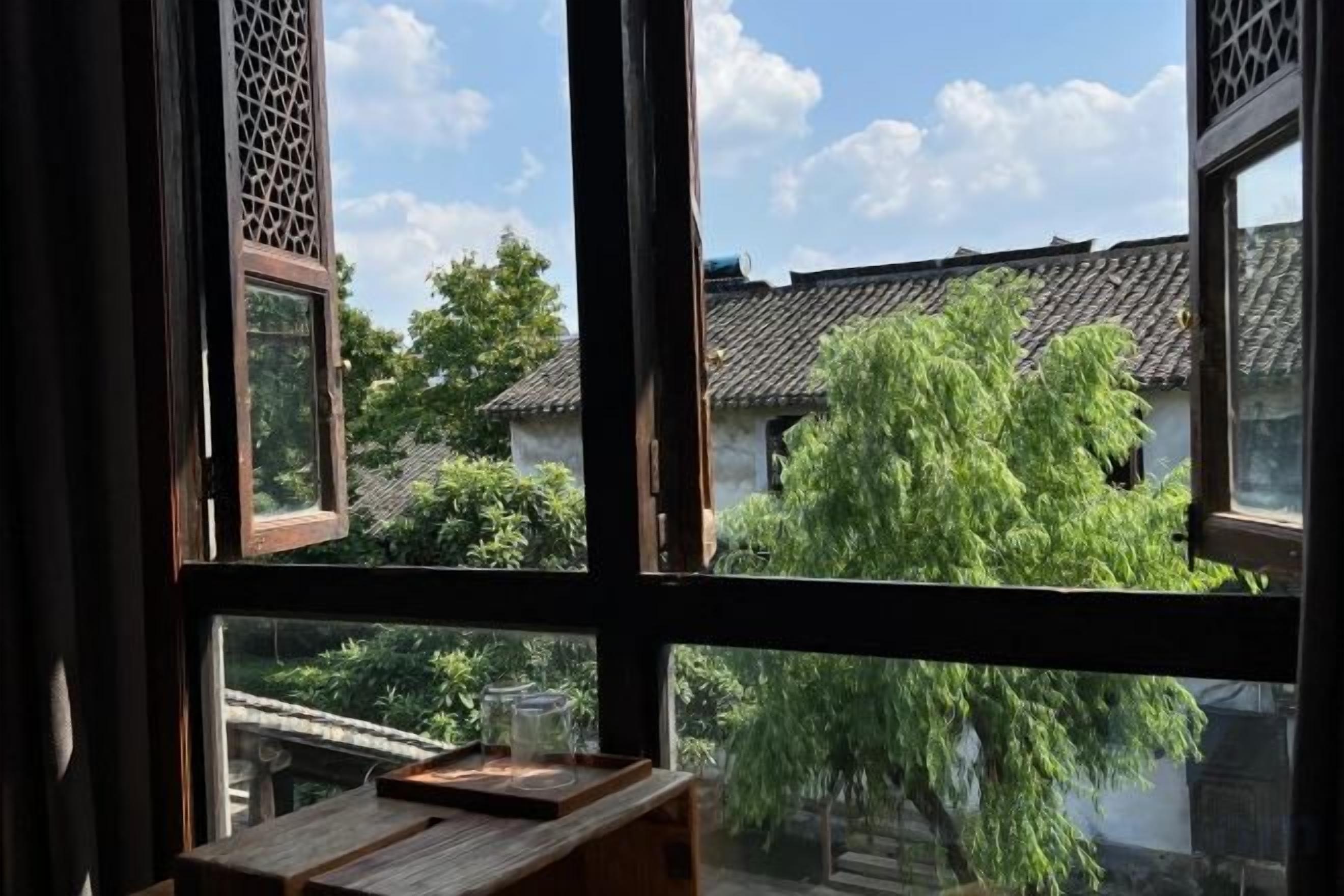 Habitación tradicional con vista a un patio y una mesa de madera.