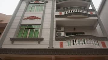 A multi-story building with balconies, air conditioning units, and traditional architectural elements.