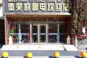 A hotel entrance with a glass facade and a sign above the doors. - Jingtai Jingdian Hotel (Jingtai)