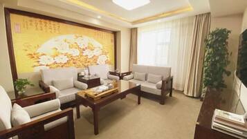 A living room with two sofas, a coffee table, and a large painting on the wall.
