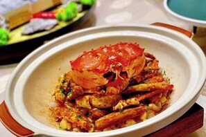 Une assiette de nourriture contenant du crabe et des légumes.