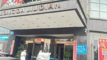 A building with a sign that reads 'DONGDA JUDDIAN' and a lion statue in front.