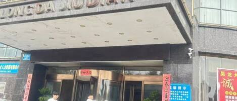 A building with a sign that reads 'DONGDA JUDDIAN' and a lion statue in front.