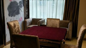 A room with a table and four armchairs, a red tablecloth, and a floral painting on the wall. - Hengyang Panlong Hotel (Hengyang County)