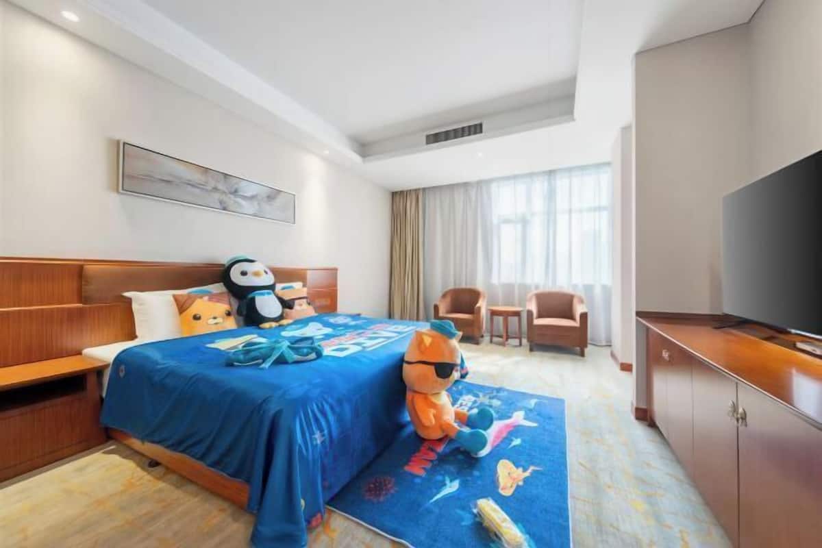 Une chambre d’hôtel avec un lit, une télévision, un bureau et une chaise.