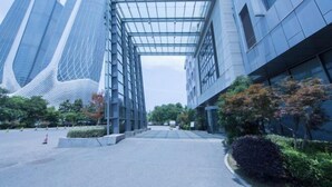 A modern building with a glass facade and a covered walkway. - Nanjing Expo Center Hotel (Nanjing)