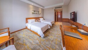 A hotel room with two beds, a desk, a chair, a television, and a carpeted floor. - Nanjing Expo Center Hotel (Nanjing)