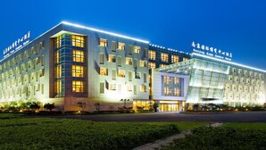 A hotel with a modern facade, multiple windows, and a well-lit entrance. - Nanjing Expo Center Hotel (Nanjing)