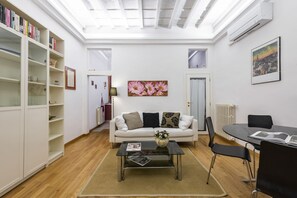 A living room with a sofa, coffee table, and bookshelves. - Charming Santo Spirito 1bdr apartment (Firenze)