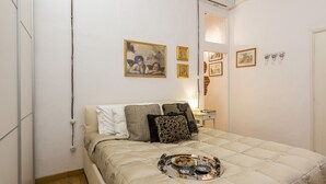Quarto com cama, bandeja com objetos e decoração na parede.