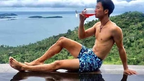 A person sitting by a pool with a view of the sea and greenery. - Best World Vision (Koh Samui)