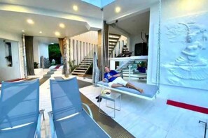 Un interno moderno con zona relax, una scala e un muro con scultura a rilievo.