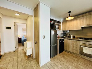 A modern kitchen with wooden cabinets, a stainless steel refrigerator, and a dishwasher. - Sea View Apartment Reñaca - Home Office & Parking (Viña del Mar)