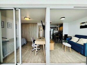A modern apartment with a dining area, kitchenette, and a living room with a sofa. - Sea View Apartment Reñaca - Home Office & Parking (Viña del Mar)