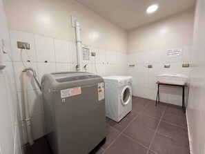 Un cuarto de lavado con lavadora, secadora y una pequeña mesa con un cesto.