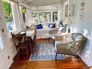 A cozy room with a bed, two wicker chairs, a table, and a rug. - 502 Walnut in Lakeside (Lakeside)
