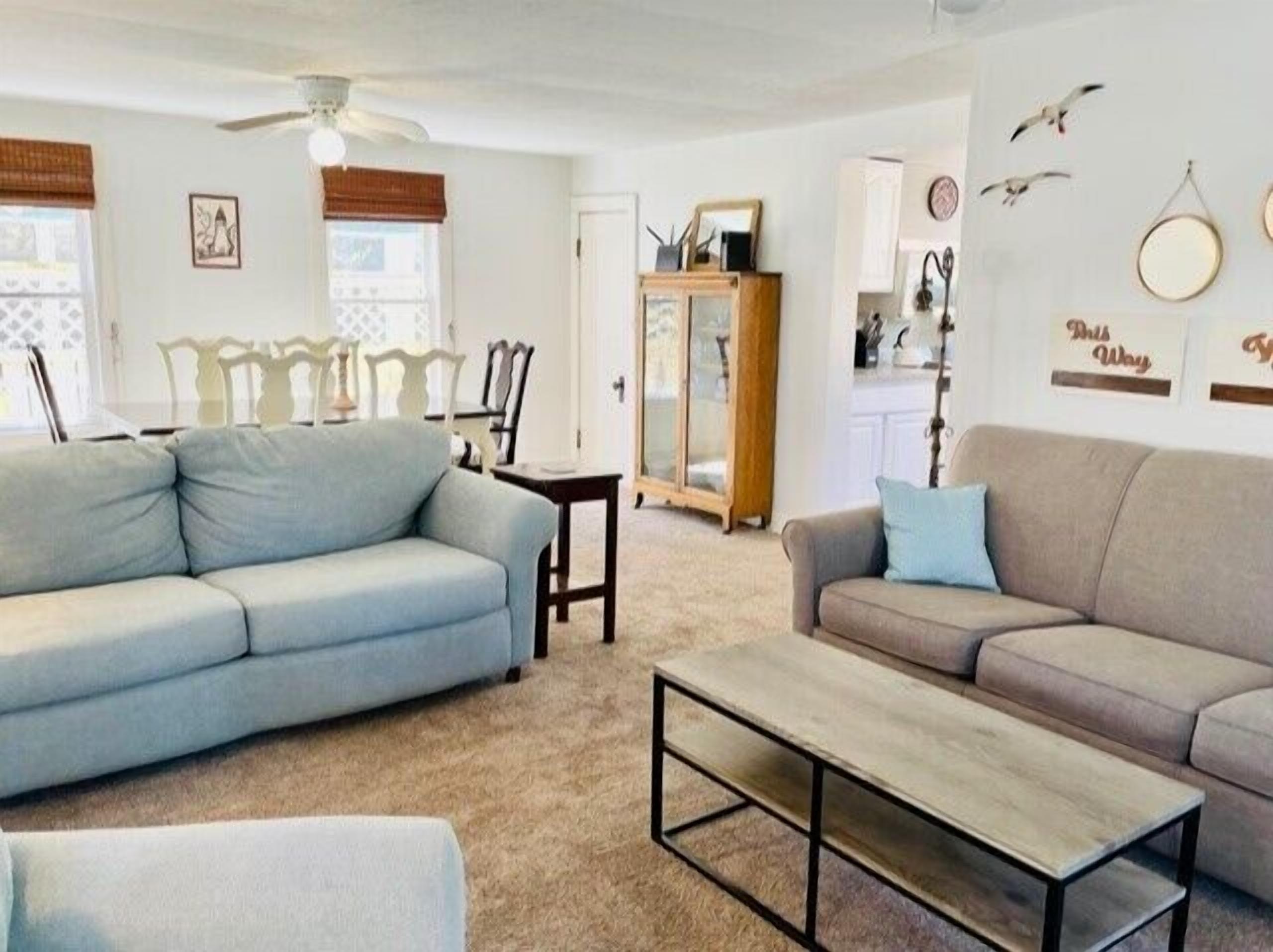 A living room with two sofas, a coffee table, and a ceiling fan.