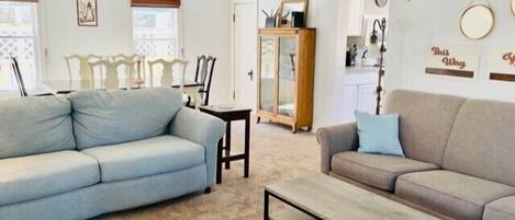 A living room with two sofas, a coffee table, and a ceiling fan.
