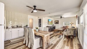 A spacious living area with a wooden dining table, a sofa, and a television. - Charming Casita in Cave Creek (Cave Creek)