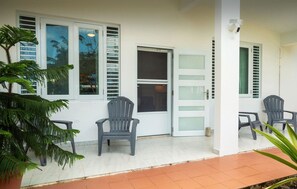 Guests can enter through one of two doors, accessing a room with a waiting area featuring two chairs on a tiled floor.
