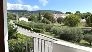 A road with a cyclist, surrounded by greenery and buildings in the background. - S342 - Sirolo, comfortable three-room apartment near the center (Sirolo)
