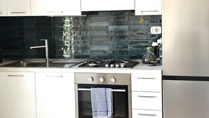 A modern kitchen with white cabinets, a stainless steel sink, a gas stove, and a built-in oven. - S342 - Sirolo, comfortable three-room apartment near the center (Sirolo)