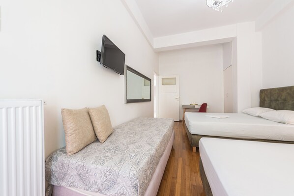 Une chambre avec deux lits, une télévision, un bureau et une chaise.