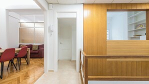 Ένας μοντέρνος εσωτερικός χώρος με τραπεζαρία, έναν καναπέ και έναν τοίχο επενδυμένο με ξύλινα πάνελ.
