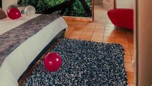 A bedroom with a large bed, a mural of a tree with a bird, and a red chair. - large villa with 8 luxury rooms, pool with lights, 3 hydrotherapy, gym, wifi !!  (Pereira)
