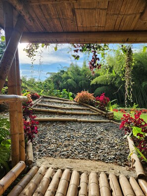 A garden pathway with bamboo structures and various plants.
