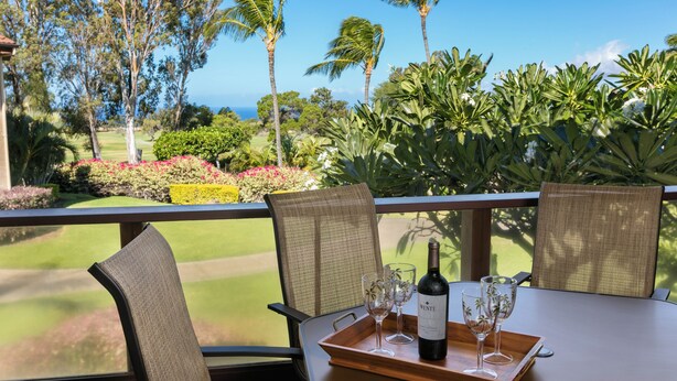 A dining table with a bottle of wine, glasses, and a tray. - Ocean view with amazing sunsets! (Waikoloa)