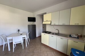 Cafetera o tetera, frigorífico, placa de cocina y utensilios de cocina