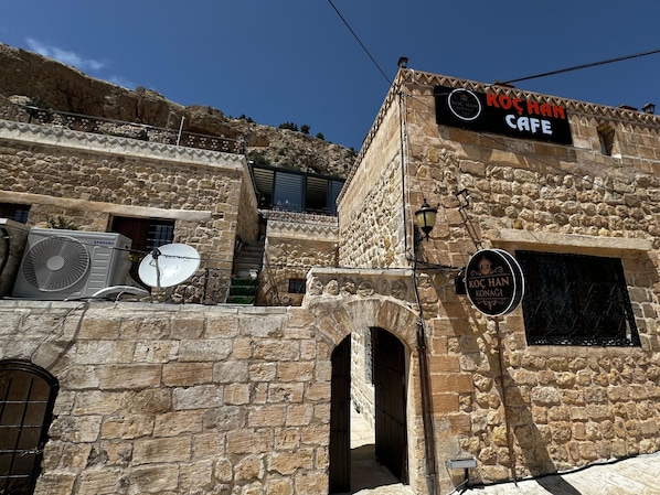 Un edificio de piedra con un letrero que dice 'Koç Han Cafe'.