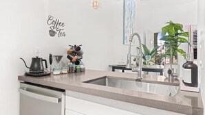A modern kitchen with a coffee machine, kettle, and various kitchen items on the counter. - ~The Hidden Gem~ King Bed and Hot Tub!

 (Chandler)