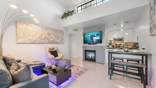 A modern living room with a sofa, coffee table, and a flat-screen TV. - ~The Hidden Gem~ King Bed and Hot Tub!

 (Chandler)