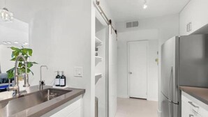 A modern kitchen with stainless steel appliances, a sink, and a plant. - ~The Hidden Gem~ King Bed and Hot Tub!

 (Chandler)