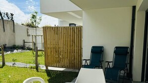 A patio with a white table and chairs, a wooden fence, and a grassy area. - 3-room town center, enclosed garden, 150m from the beach (ST PIERRE QUIBERON)