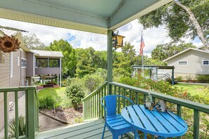 Relax on the serene porch with a comfortable table and chair, surrounded by a well-maintained garden.