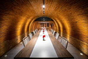 A long conference table with chairs, set in a brick-walled room with a high ceiling. - Hotel Casa Chanehque (San Pedro Cholula)