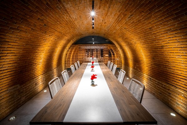 A long conference table with chairs, set in a brick-walled room with a high ceiling. - Hotel Casa Chanehque (San Pedro Cholula)