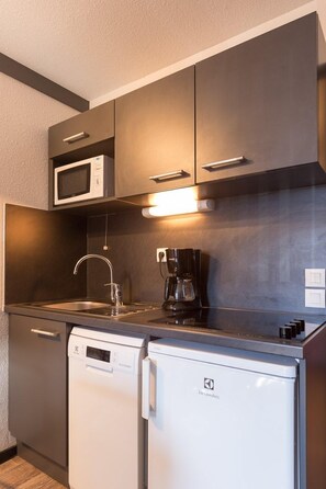 Een koelkast, een microgolfoven, een kookplaat, een vaatwasser