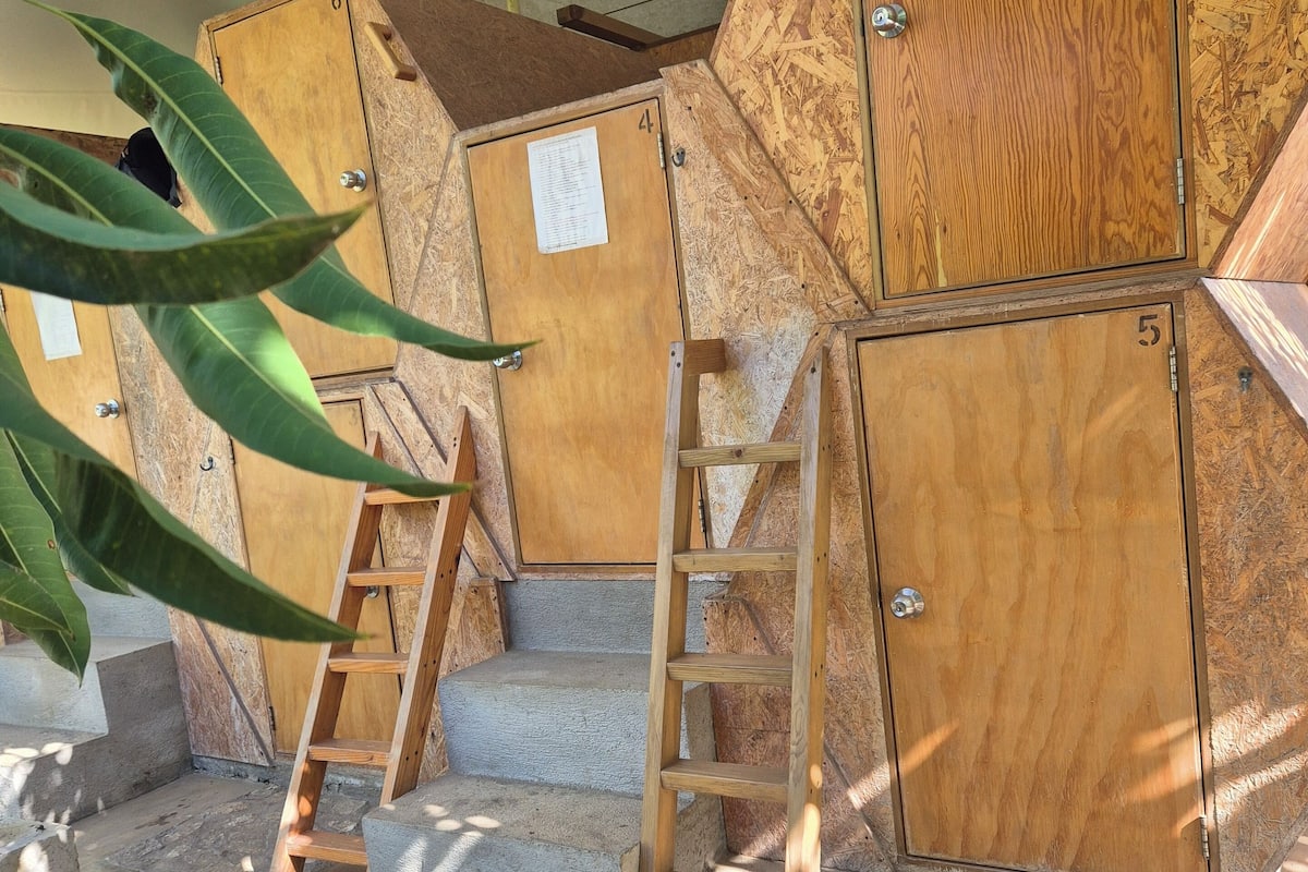 A set of wooden cabinets with numbers 4, 5, and 6, and a wooden ladder leading to a set of concrete steps.