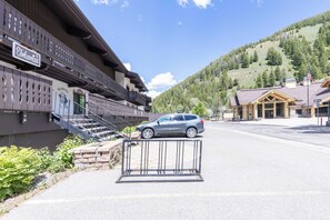 A building with a balcony and a car parked in front.