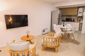 Cozy living space with a flat-screen TV, kitchenette, and comfortable seating area.