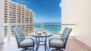 Enjoy ocean views from this balcony with a round table and two chairs.