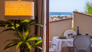 Een eetgedeelte met een tafel voor twee personen, een hanglamp en uitzicht op het strand.