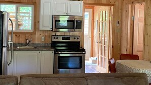 A wooden cabin interior with a kitchenette, a sofa, and a dining area. - Cozy Cabin in Grand Beach.  (Grand Marais)